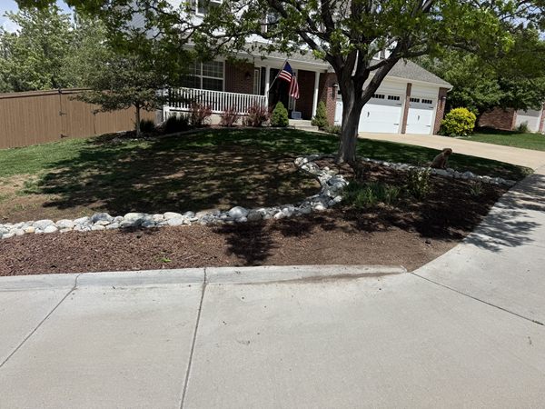 After: clean mulch bed with a river-rock border