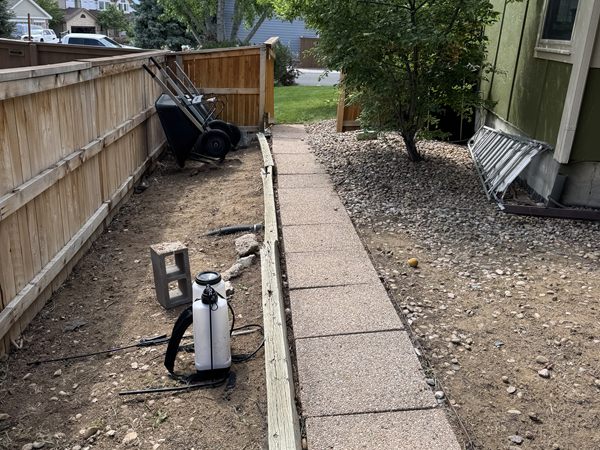 After: side yard cleared to bare ground along the walkway